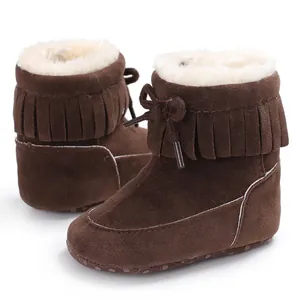 Close-up of warm brown baby snow boots featuring soft white plush lining and fringe details.