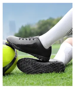 Dettaglio scarpe da calcio nere professionali per bambini su campo in erba sintetica