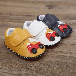 Vue détaillée de trois chaussures de marche pour bébé avec motifs de voitures et semelles.