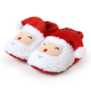 Nahaufnahme der weichen Plüsch-Babyschuhe im Weihnachtsmann-Design für den Winter