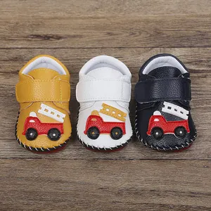 Détail des chaussures pour bébé avec un motif de camion de pompier et semelle en gomme