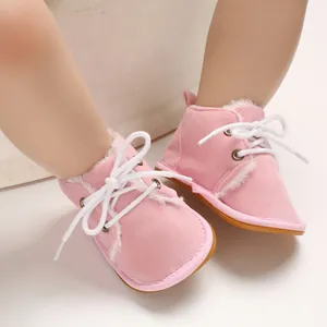 Süße rosa Babyschuhe aus Wildlederimitat mit warmem weißem Fellfutter und Schnürung.