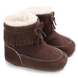 Close-up of brown baby snow boots with fringe detail and soft white faux fur lining.
