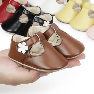 Detailed view of brown faux leather baby princess shoes featuring a white flower
