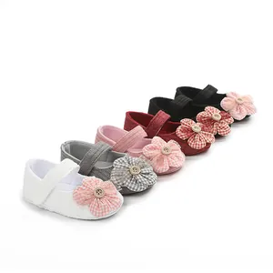 Vista detallada de zapatos de bebé estilo princesa con flores de tela a cuadros