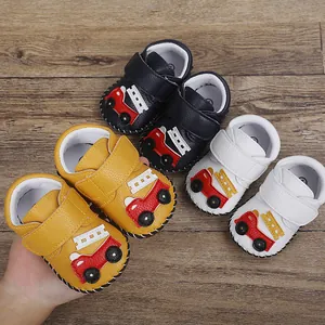Détail des motifs de camions de pompiers sur des chaussures de marche pour bébé à semelle souple