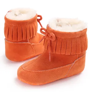 Close-up of vibrant orange baby fringe snow boots with thick warm faux fur lining details