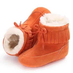 Close-up view of warm orange infant snow boots with soft white faux fur lining detail