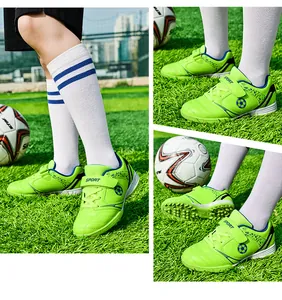 Detailansicht der lindgrünen Kinder-Fußballschuhe auf einem Rasenplatz