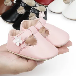 Detailed macro shot of pink baby girl princess shoes with T-strap and white flower decor