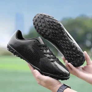 Scarpe da calcio nere professionali per bambini per l'allenamento su campi in erba