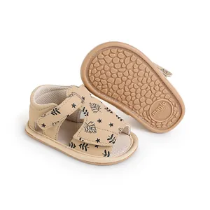 Detailed view of baby sandals featuring black leaf patterns and anti-slip rubber soles