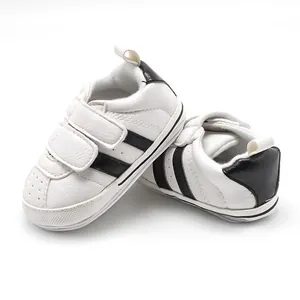 Close-up of white baby walking shoes with black stripes and anti-slip rubber soles