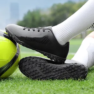 Scarpe da calcio nere professionali per bambini e adulti su erba con pallone da calcio