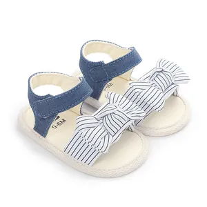 Detailansicht von süßen Babysandalen mit blauen Denim-Riemen und gestreifter Schleife