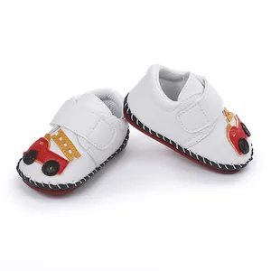 Détail de chaussures de marche pour bébé blanches avec motif de camion de pompier