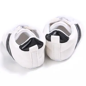 Vista trasera de zapatillas blancas para bebé con talón negro y suelas blandas