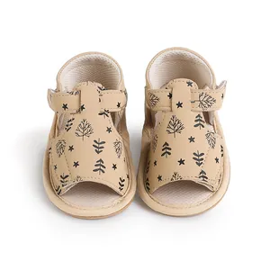 Detailed front view of tan baby pre-walker sandals with tree and star patterns
