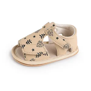 Detailed side view of beige baby walker sandals with black leaf and star patterns