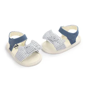 Detailansicht der Baby-Lauflernsandalen mit Jeansriemen und einer gestreiften Schleife