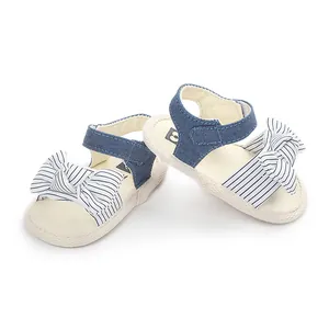 Nahaufnahme von blauen Baby-Sandalen mit gestreifter Schleife und weicher Sohle