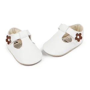 Detailed view of white leather baby girl princess shoes featuring cute brown flower decor