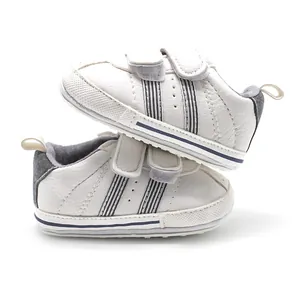 White faux leather baby walking shoes with double velcro straps and non-slip rubber soles