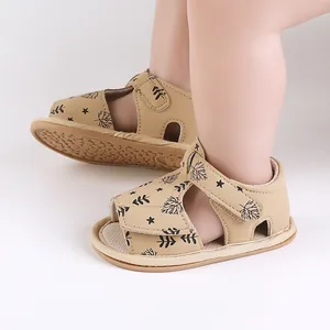 Cute beige baby summer beach sandals featuring leaf patterns on infant feet close-up view