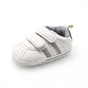 Detailed side view of white baby pre-walker shoe with velcro straps and stripes.