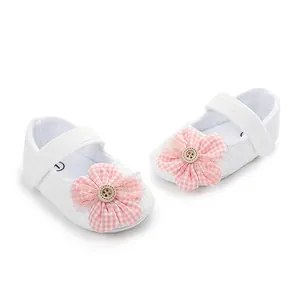 Primer plano de zapatos de princesa para bebé con flor de cuadros rosa y botón de madera