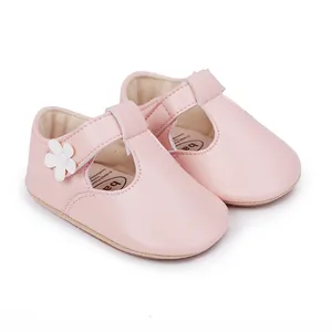 Detail shot of pink baby girl princess shoes with flower and T-strap closure.
