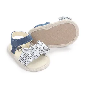 Detailansicht von Baby-Denim-Sandalen mit gestreifter Schleife und Sohlen.