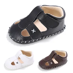 Detailansicht von Baby-Sommersandalen aus schwarzem weißem und braunem Lederimitat