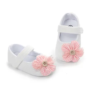 Primer plano de zapatos blancos de bebé niña con flores rosas y botones
