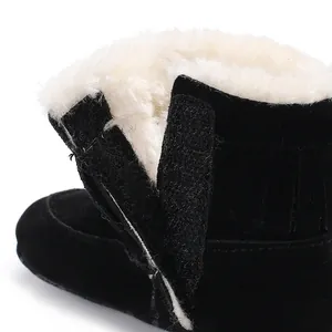 Close-up of warm white fleece lining and black suede texture of baby snow boots