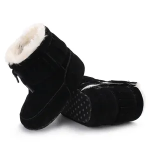 Detailed close-up of black infant winter snow boots with soft faux fur lining and fringe