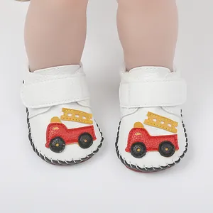 Gros plan de chaussures de marche pour bébé avec motif de camion de pompiers rouge