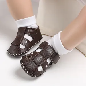 Detailansicht brauner Leder-Lauflernsandale für Babys mit weißen Söckchen.