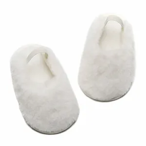 Dettaglio di morbide scarpine neonato bianche in peluche per bambini dai 0 ai 12 mesi