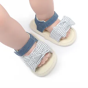 Detailansicht von Baby-Lauflern-Sandalen mit gestreifter Schleife und Jeansriemen für den Sommer.