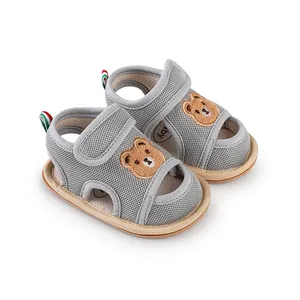Detailansicht von atmungsaktiven grauen Mesh-Babysandalen mit süßem Cartoon-Bär-Aufnäher