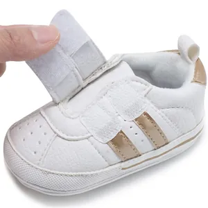 Detail view of white baby pre-walker shoe with adjustable gold velcro straps