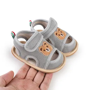 Nahaufnahme von atmungsaktiven grauen Baby-Sandalen mit süßer Cartoon-Bären-Stickerei