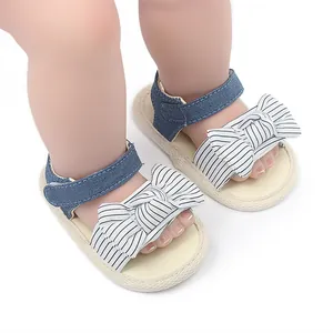 Detaillierte Nahaufnahme von Baby-Sandalen mit gestreifter Schleife und blauem Klettverschluss