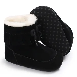 Detailed macro view of black baby snow boots featuring fringe and soft warm fleece lining