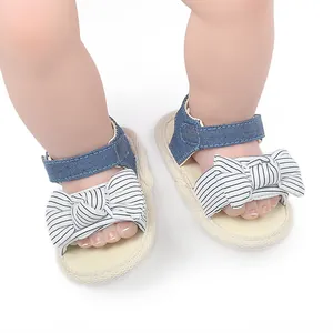 Detailansicht von Baby-Sommersandalen mit gestreifter Schleife und blauem Jeansriemen