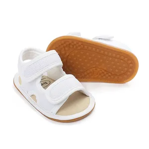 Nahaufnahme weißer Baby-Sandalen mit rutschfesten Gummisohlen und Klettverschluss-Detail