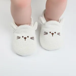 Soft white knitted baby walker shoes with cute embroidered cartoon cat face design.