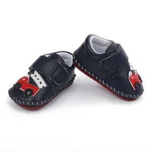 Vue détaillée de chaussures pour bébé bleu marine avec voiture rouge et scratch