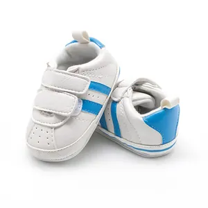 Close-up view of white and blue infant pre-walker sneakers with durable rubber soles